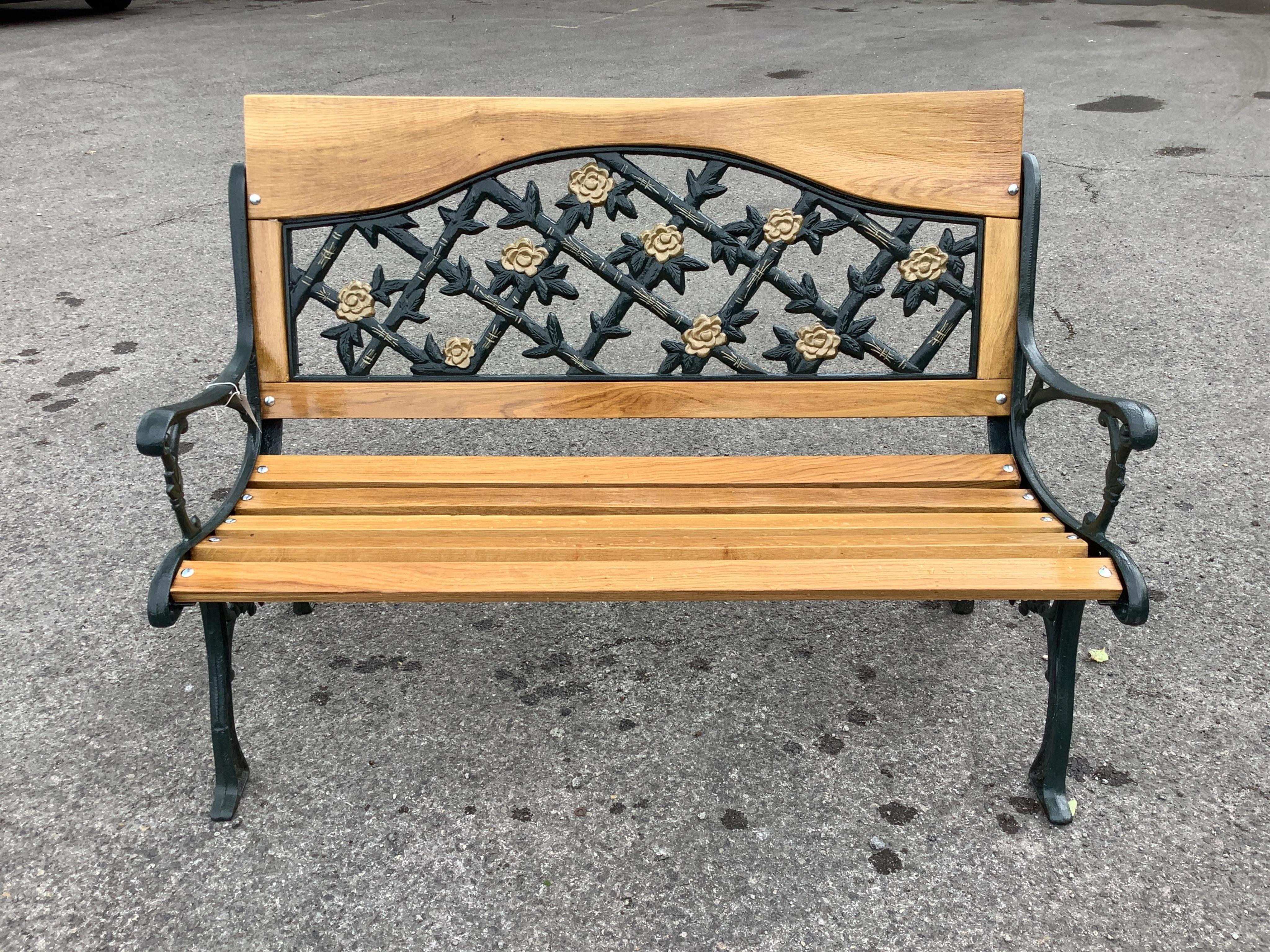 A Victorian style cast metal and slatted wood garden bench, width 130cm, height 90cm
